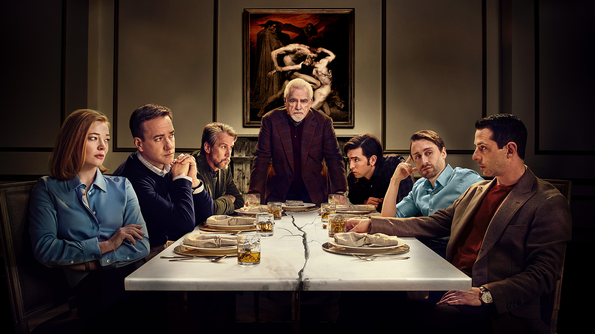 The cast of Succession poses at a dinner table. A crack spreads across the table itself.